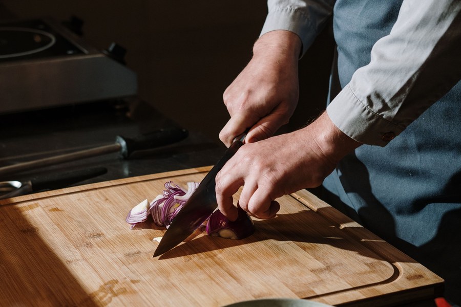 Chefs plating identical dishes to the same standard on a restaurant pass